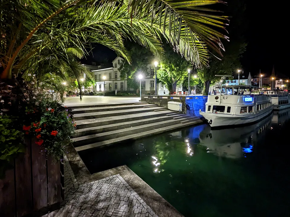 Hafen von Überlingen bei Nacht mit Booten und Palmen